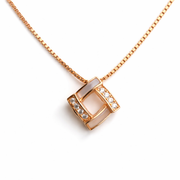Rose gold necklace with a square pendant on a white background