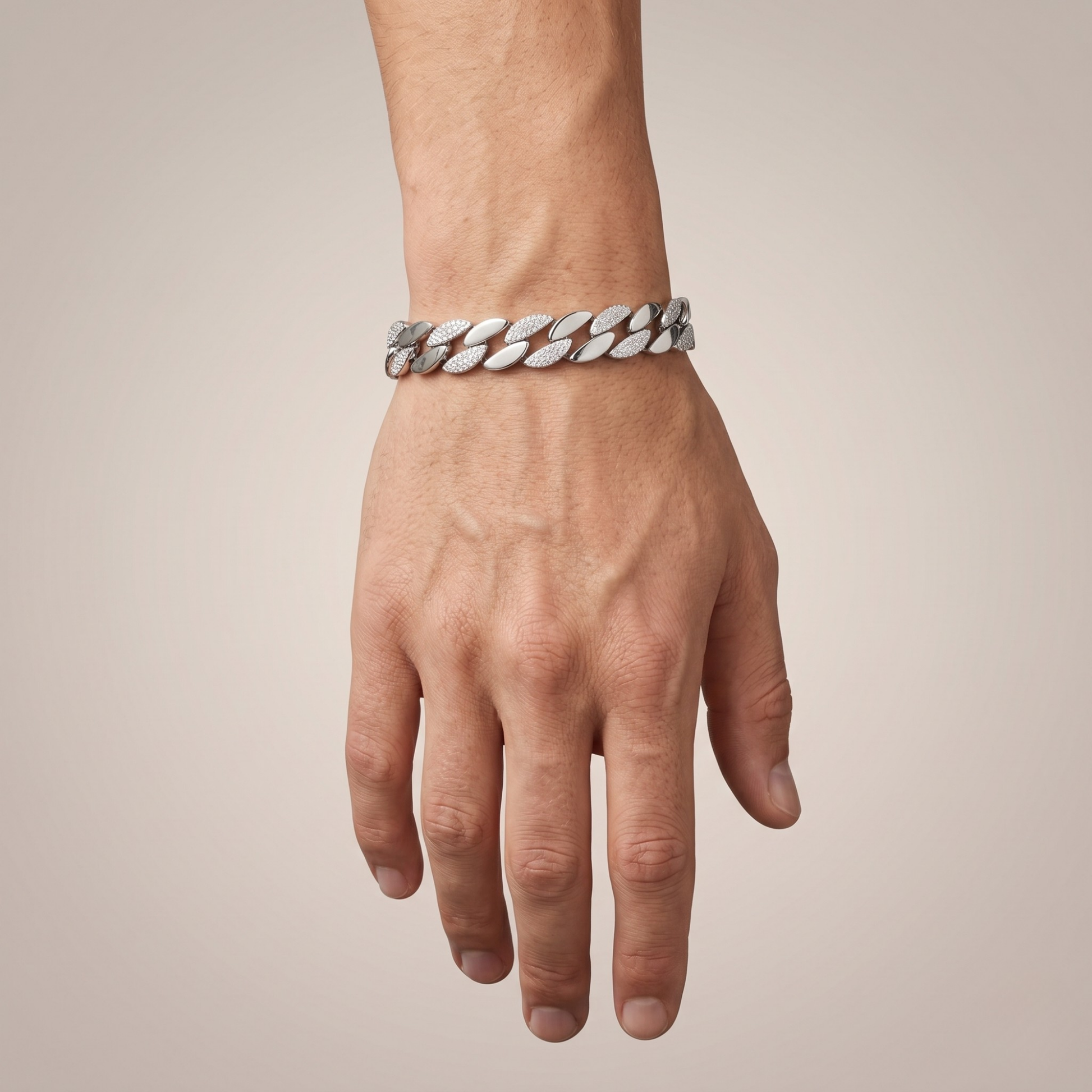 Hand wearing a silver bracelet on a beige background
