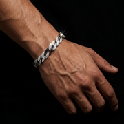 Hand wearing a silver chain bracelet on a black background