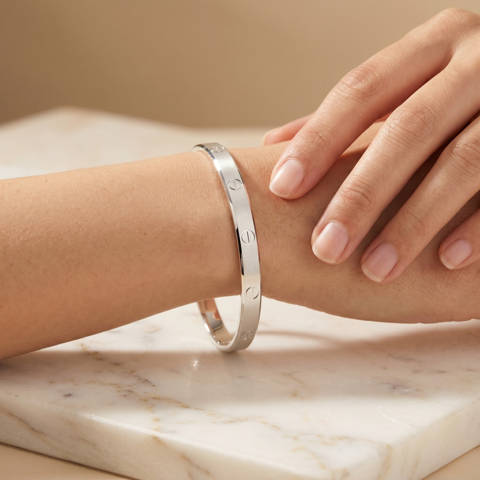 Silver bracelet on a wrist with a neutral background