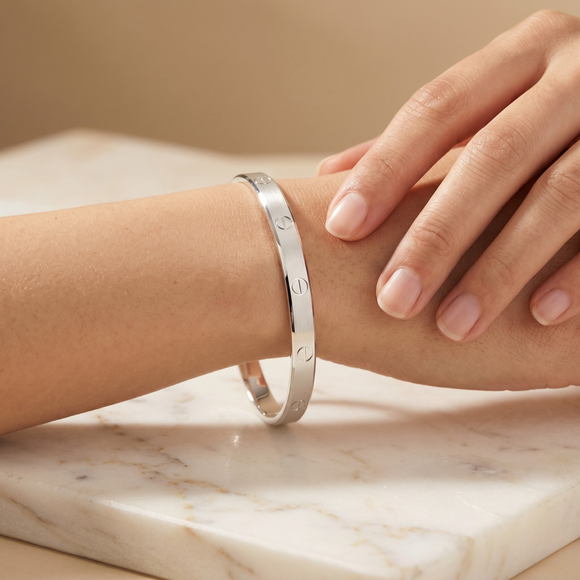 Silver bracelet on a wrist with a neutral background