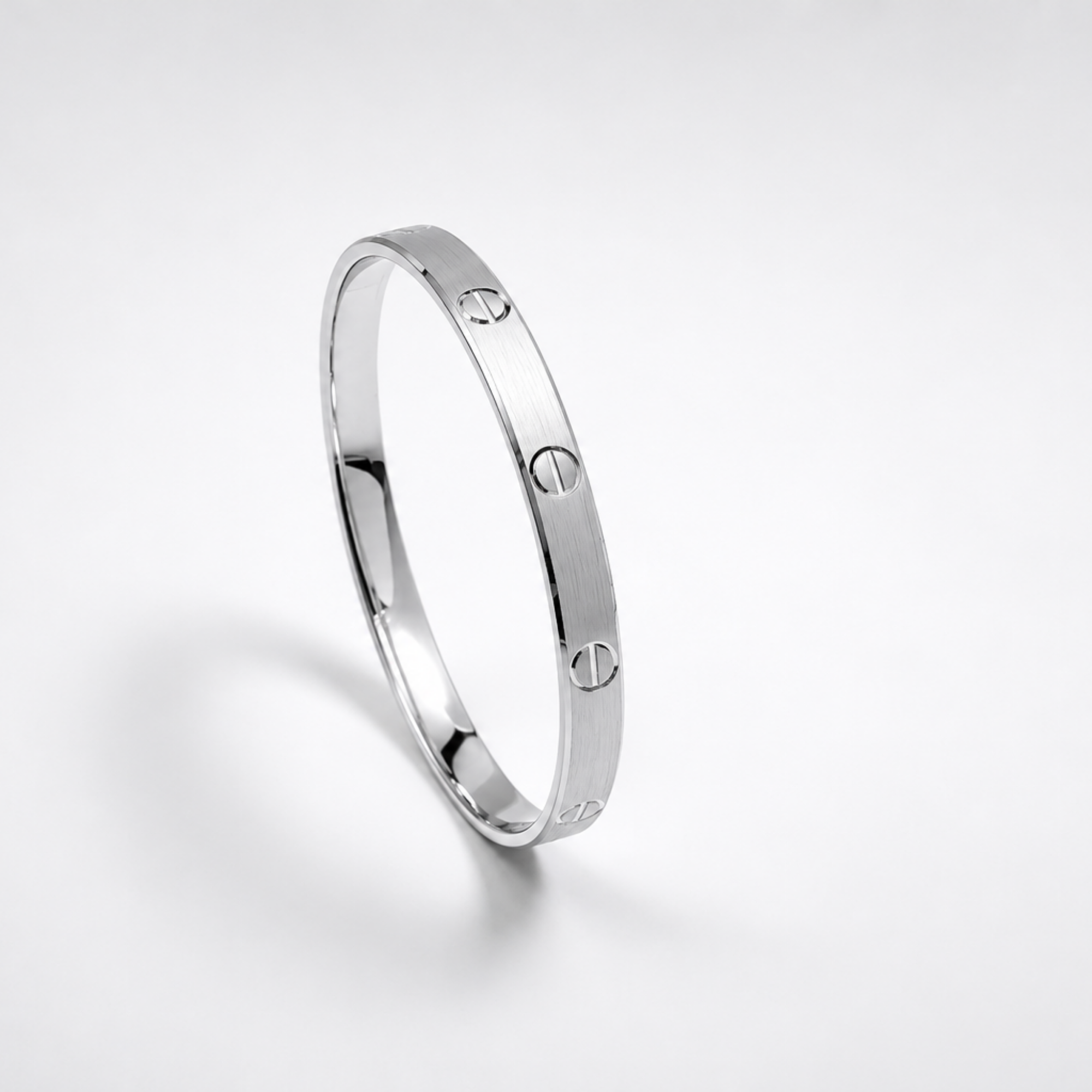 Silver ring with engraved design on a light gray background