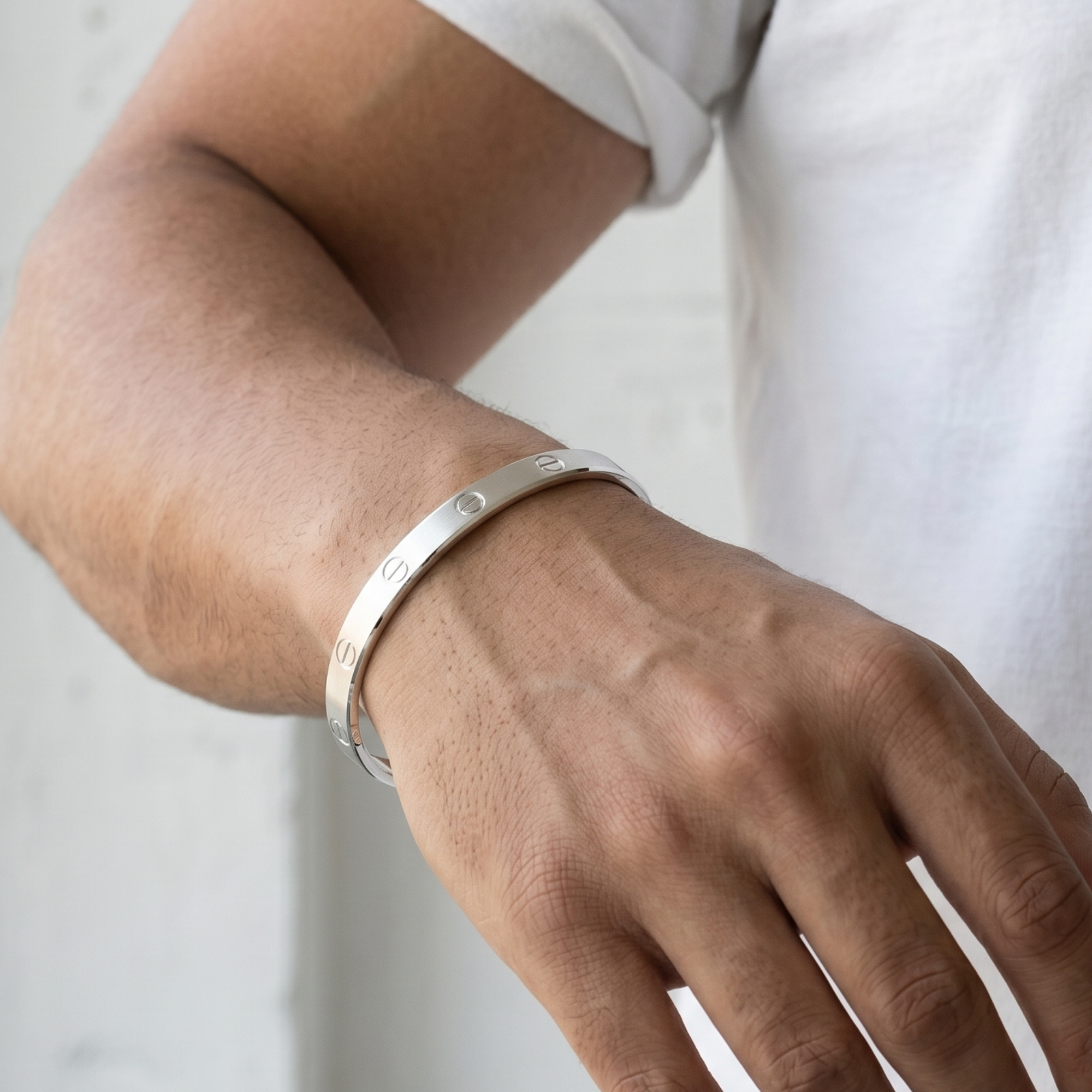 Silver bracelet on a wrist with a neutral background