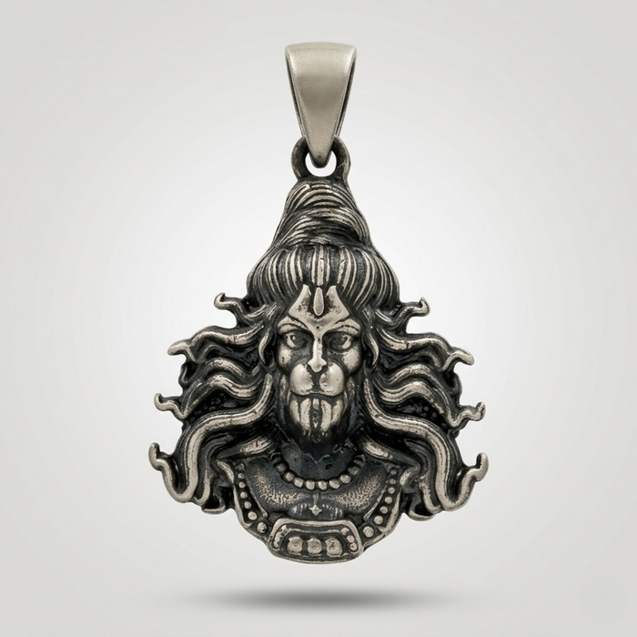 Silver pendant with intricate design on a light gray background