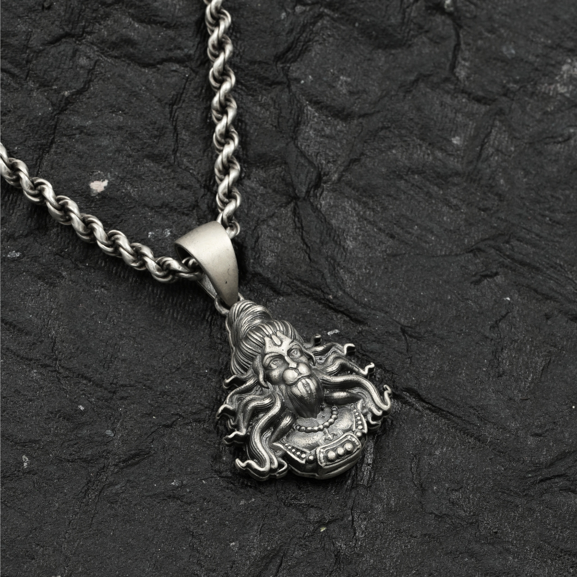 Silver pendant necklace on a textured black background