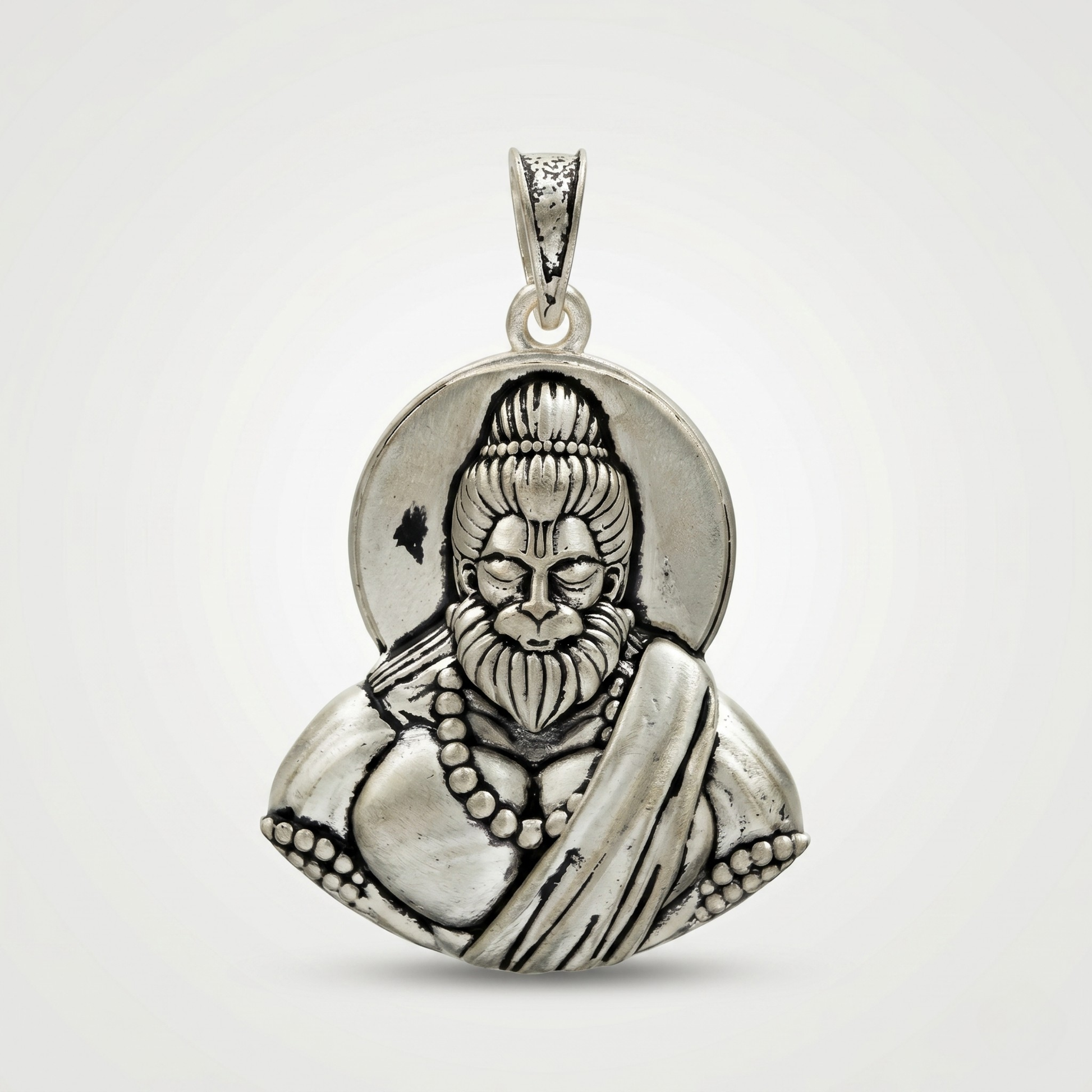 Silver pendant with a detailed design on a white background