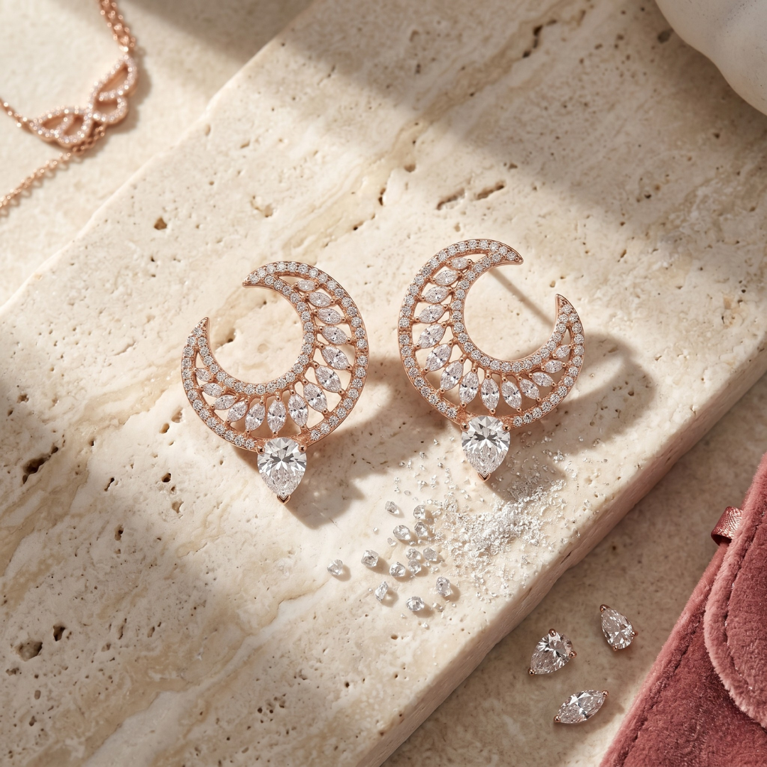 Rose gold earrings with diamonds on a textured surface